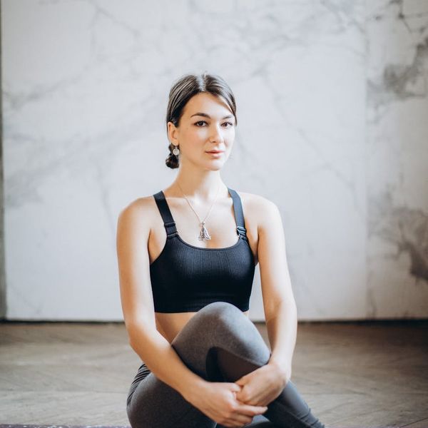 Person stretching on a yoga mat in a sunlit room.